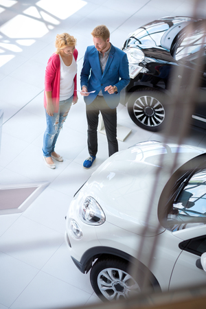 Dealer in a dealership speaking with a clientの写真素材
