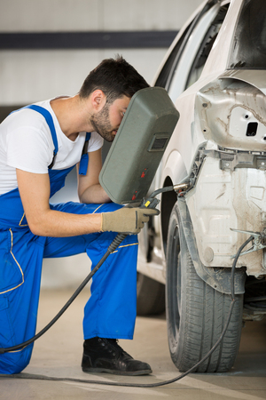 mechanic welding car body in serviceの写真素材