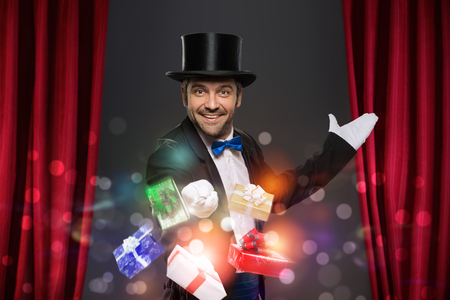 Cheerful magician performs the trick with magic boxの写真素材