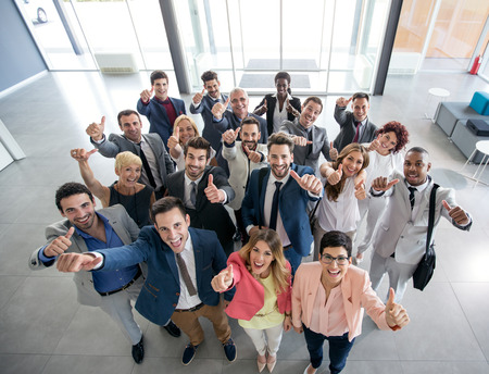 Portrait of thumb up smiling business people