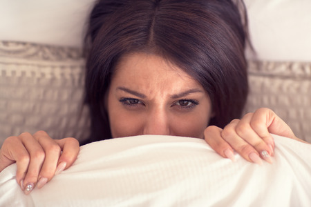 Young pretty female wake up hardly from bed in early morningの写真素材