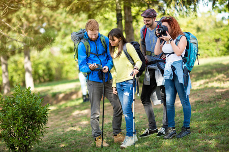 Hikers with backpack takes photo and see path through forest on mapの写真素材