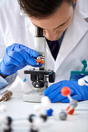 Scientist looking through a microscope in a laboratory