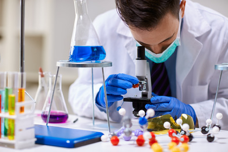 Scientist analyzing using a microscope   in a laboratory