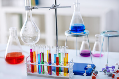 desk in chemistry lab with samples in test tubes and equipmentの写真素材
