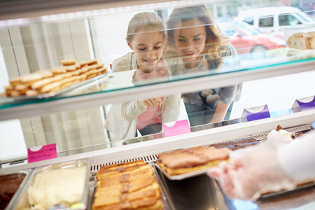 Daughter and her mother choose sweets in beautiful candy store