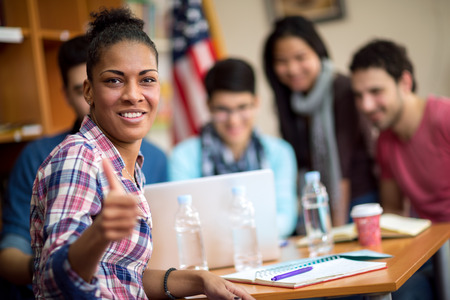 Afro American student showing thumb up in multiethnic working groupの写真素材