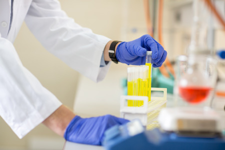 Hand of worker placing test tube in holder