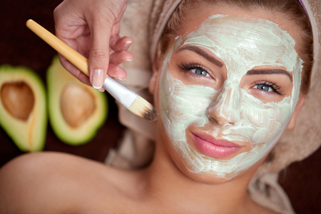 green avocado mask being applied at a beauty spaの写真素材