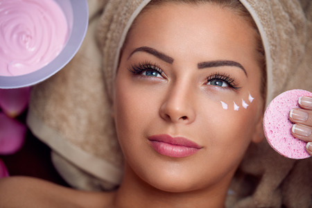 Pretty young woman with facial mask at beauty salonの写真素材
