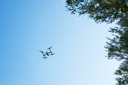 Flying drone on blue skyの写真素材
