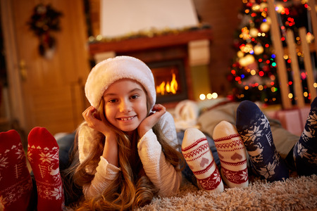 Happy girl lying on the floor on Christmas timeの写真素材