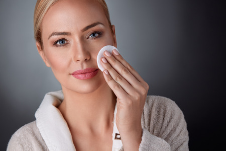 
middle aged woman cleaning her skin, health and beautyの写真素材
