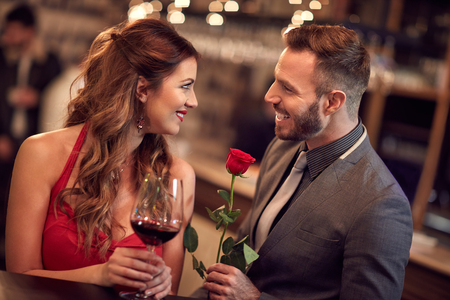 Handsome man giving rose to attractive ladyの写真素材