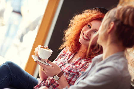 Females enjoying with cup of coffee in cafeteriaの写真素材