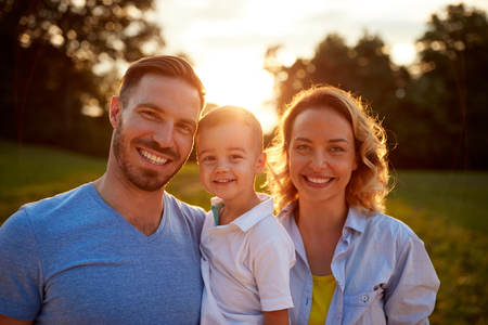 Smiling young family together outside, portraitの写真素材