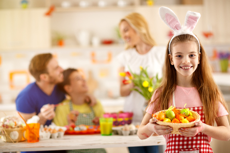 Girl show basket with painting Easter eggsの写真素材