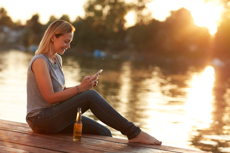 Girl resting near river at sunsetの写真素材