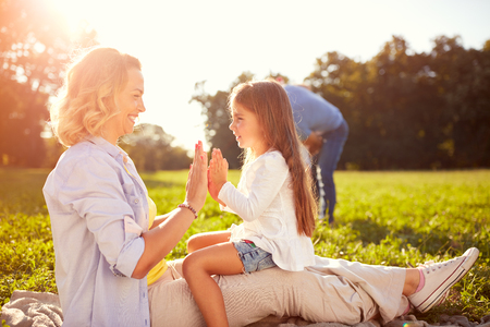 Mother play with daughter in sunny natureの写真素材