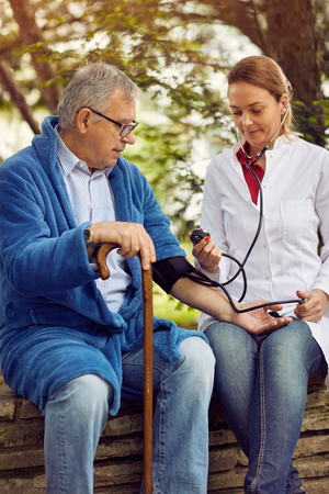 Hospitals, Labs and Clinics- Nurse assessment of blood pressure elderly manの写真素材