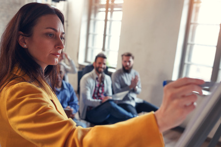business leader -woman at board teaches colleagues on seminarの写真素材