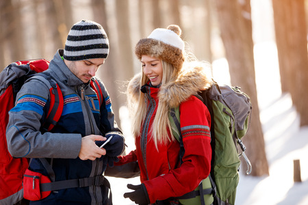 Young hikers in nature looking on cell phoneの写真素材