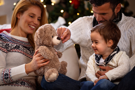 Parents play with his son with teddy bear on Christmas holidayの写真素材