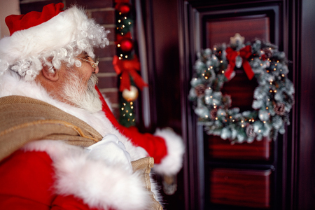 Santa Claus carrying large bag with present in Christmas nightの写真素材