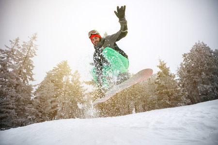 Male snowboarder in action on snowboardの写真素材