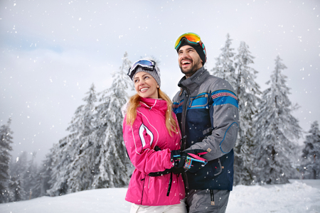 Smiling couple happy together on mountain for winter vacation の写真素材