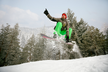 Man snowboarder in jump at ski resort in the mountain-winter sportの写真素材