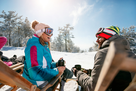 friends relax in chairs on the mountain top at sunny day. Back viewの写真素材