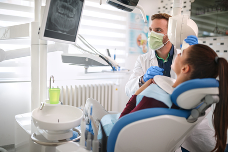 Male dentist and female patient looking at x-ray dental footage の写真素材
