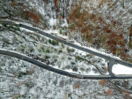 View from height on car driving through winter forest road. aerial eye winter landscapeの写真素材
