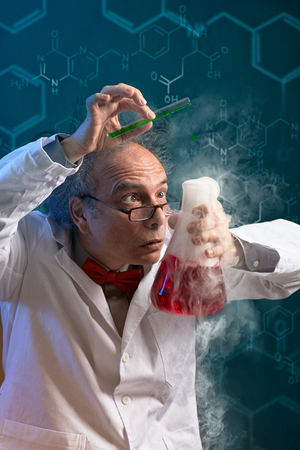 
Crazy chemist scientist focused on danger experiment over abstract background の写真素材