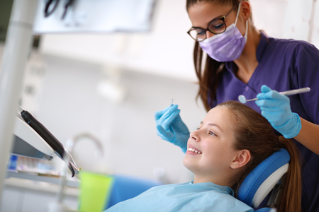 Female young patient in dental chair with female dentistの写真素材