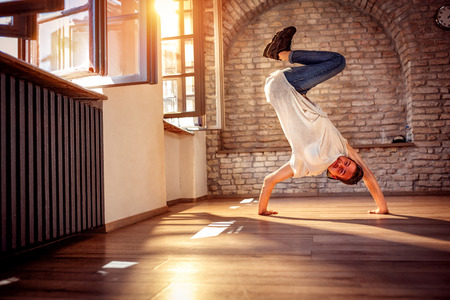 Hip hop lifestyle concept - smiling street artist break dancing performing moves 
