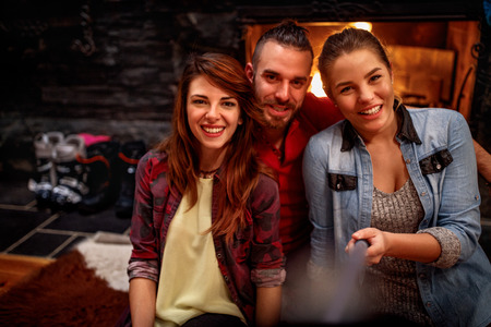 Time of relaxing after skiing- Smiling friends making selfie togetherの写真素材