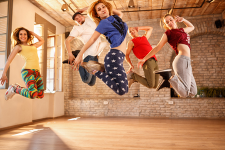 Group of dancers jumping together in dancing studioの写真素材