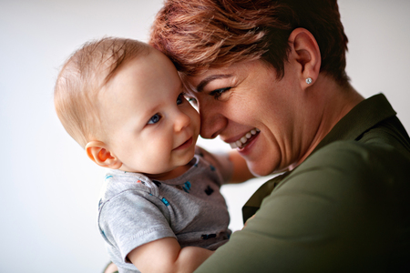 Tenderness between mom and male baby in her handsの写真素材