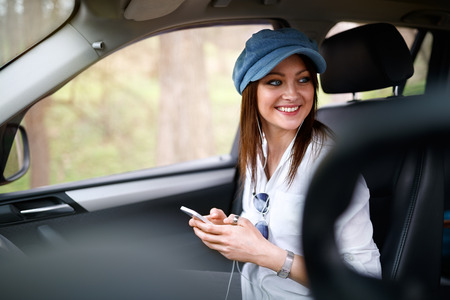Female in car listening music on cell phone