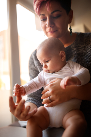 Baby playing mother's fingerの写真素材