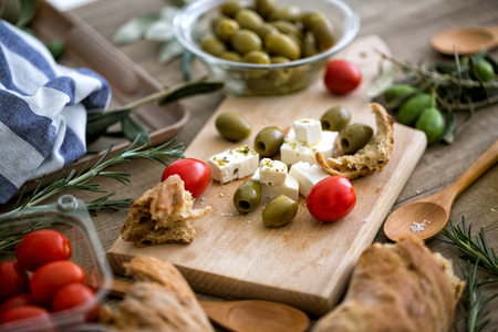 Mediterranean salad with fresh vegetables, feta cheese and green olives on wooden tableの写真素材