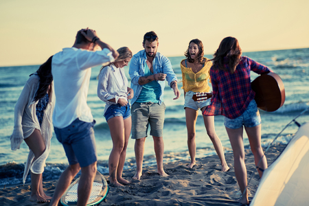 Party on beach-Group of happy young people dancing together at the beach on beautiful summer sunsetの写真素材