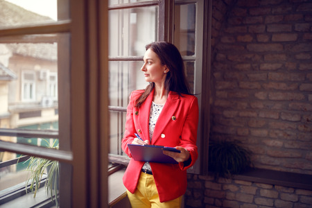 Brunet woman in studio looking through windowの写真素材