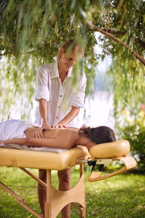 beautiful woman receiving back massage at spa. Female having relaxing massage on her back in natureの写真素材