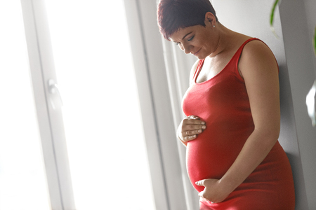 Happy pregnant young woman waiting for childの写真素材