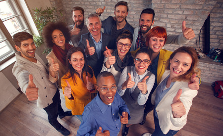 Group of smiling success business team giving thumbs up
