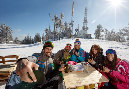 Grup skiers taking selfie together on skiing in cafe on ski terrainの写真素材