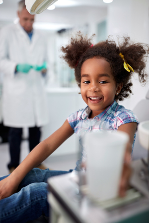 Cheerful black child after dental treatment in dental ambulanceの写真素材
